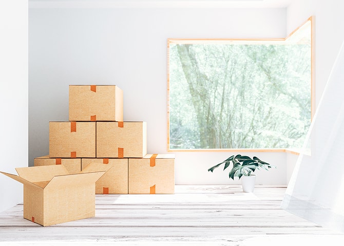 窓辺に段ボールが積まれた引っ越し準備中の室内
